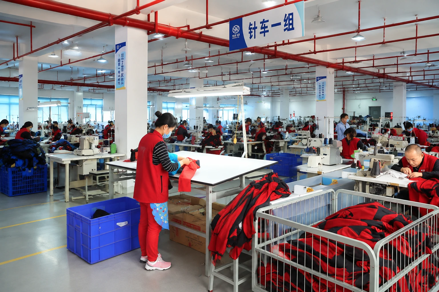 Chinese apparel production team inspecting technical outdoor jacket quality